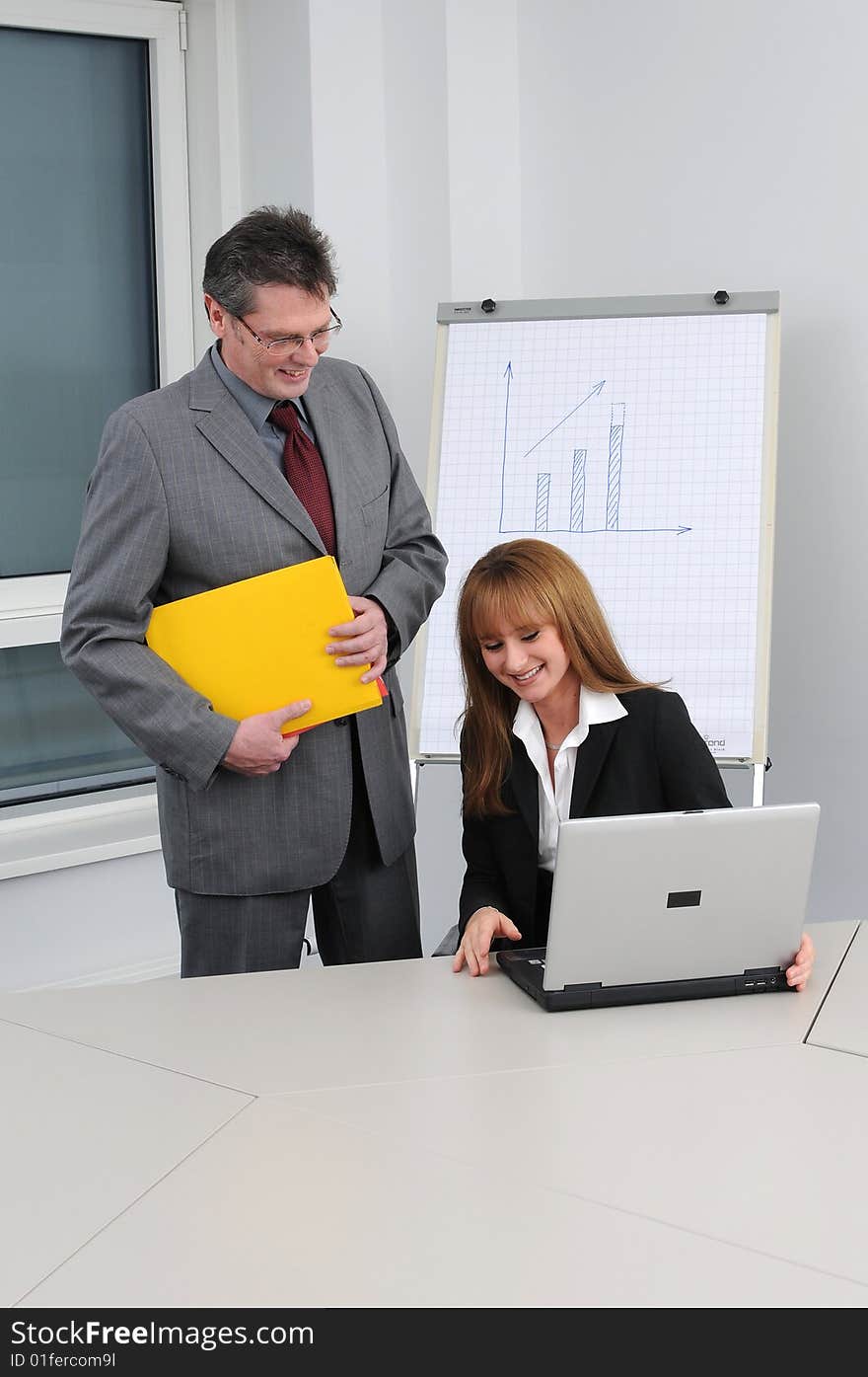 Business woman and man at the office. Laptop on the desk. Business woman and man at the office. Laptop on the desk.