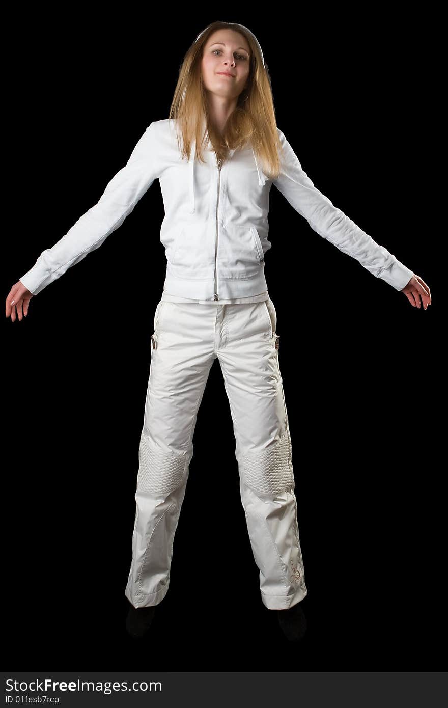 Woman in a white sports suit jumps on a black background