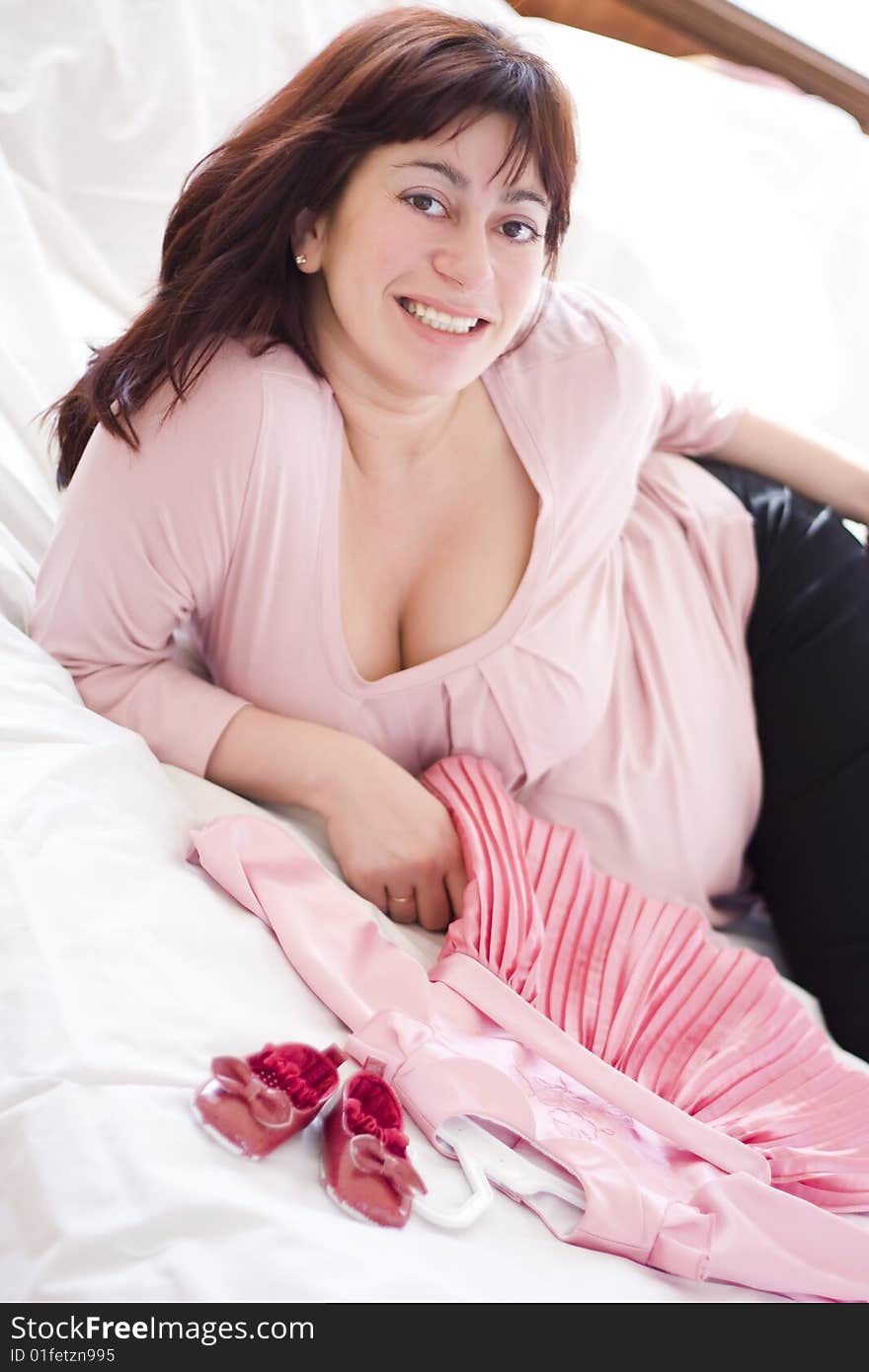 Young beautiful pregnant woman with small pink dress. Young beautiful pregnant woman with small pink dress