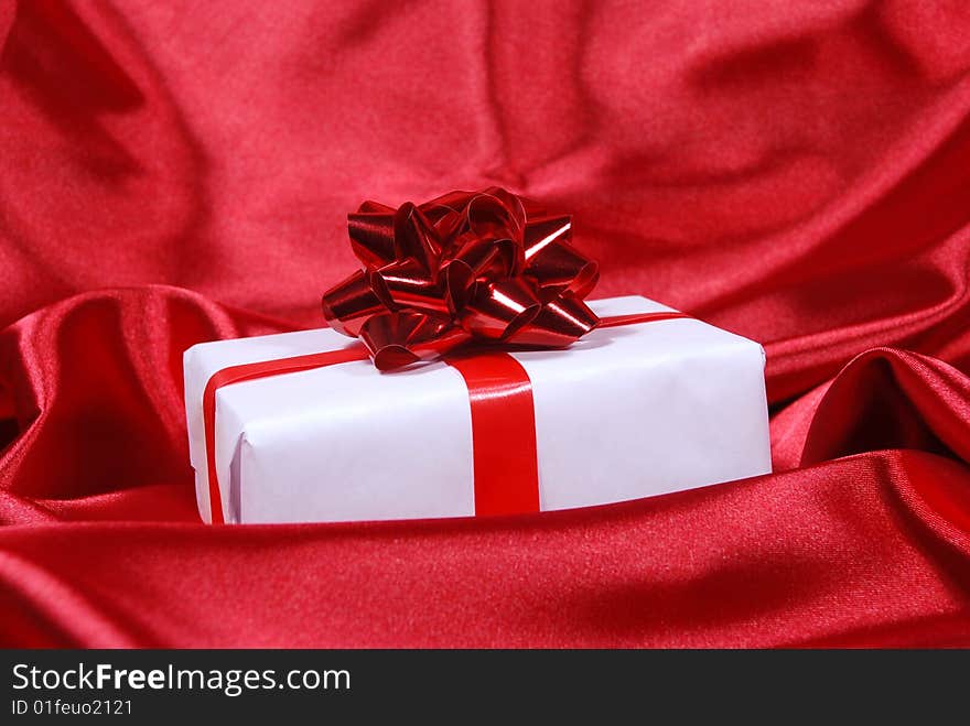 Red gift box on red satin background