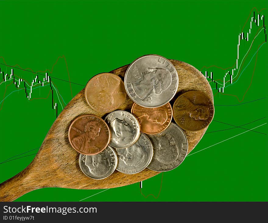 Wooden kitchen spoon with coins, on candlesticks chart, closeup. Wooden kitchen spoon with coins, on candlesticks chart, closeup.