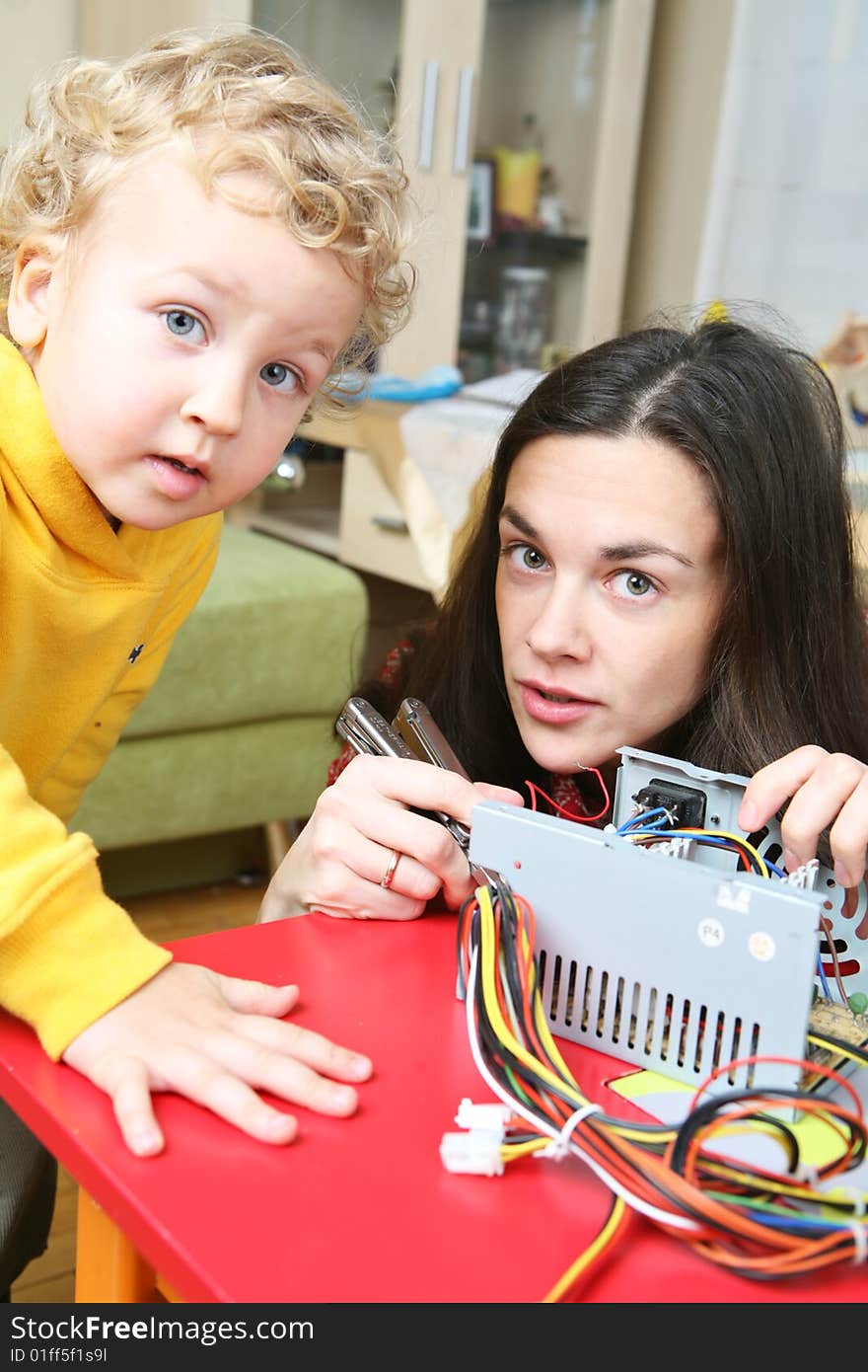 Mother and son are fixing a computer. Mother and son are fixing a computer.