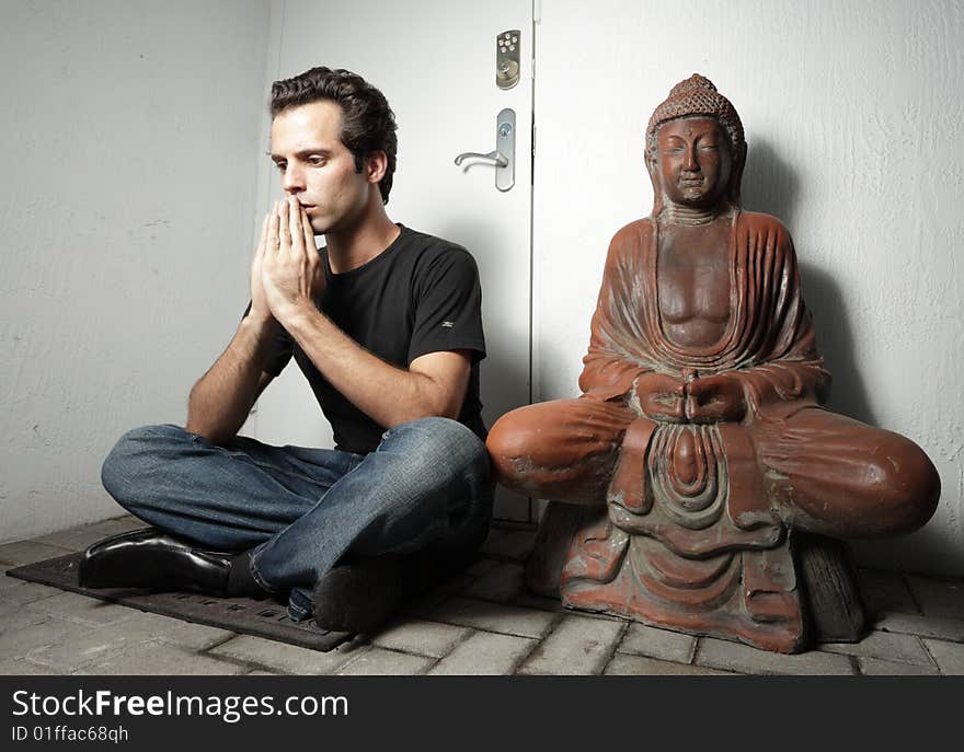 Man sitting next to a Buddha. Man sitting next to a Buddha