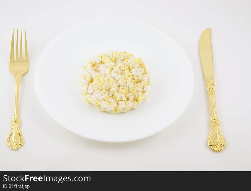 Rice cake on a plate with fork and knife.