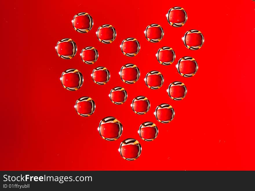 Water drops in the form of heart on a celebratory background