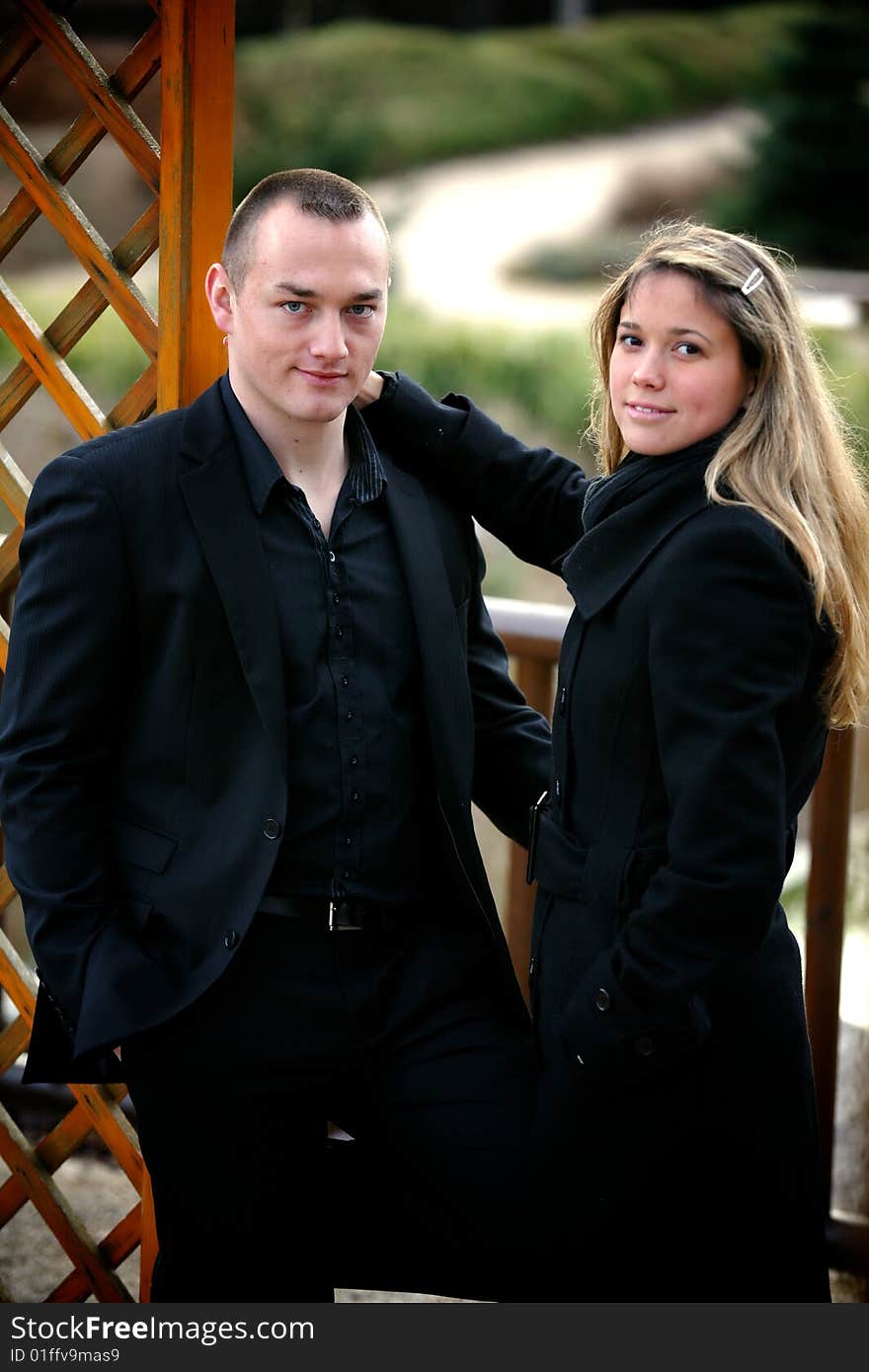 Casual couple in a park looking for the camera. Casual couple in a park looking for the camera