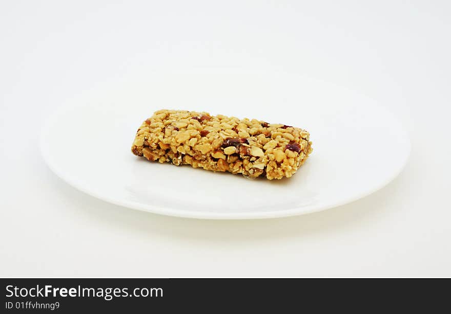 Energy bar on a plain white dish.  Great for quick boost of much needed nutrition.