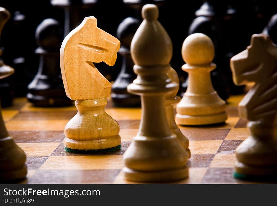 Old Craved wooden Chess pieces on a Board