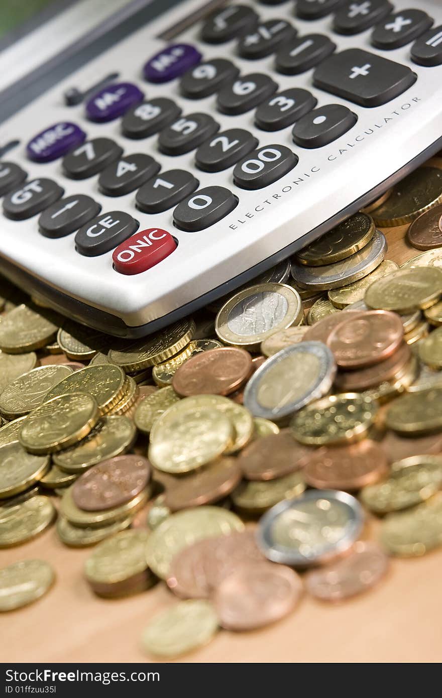 Pocket calculator and euro coins on table