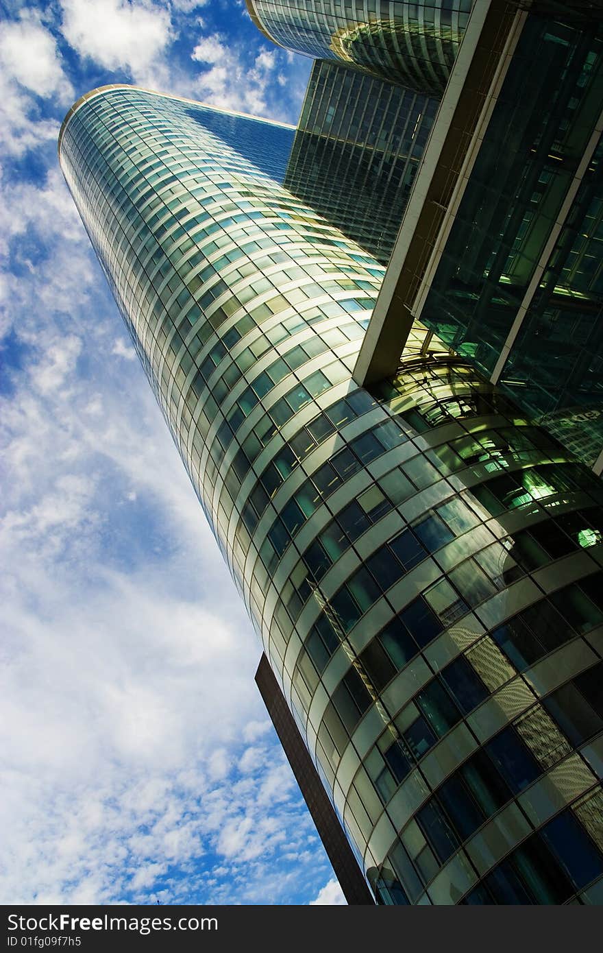 Modern skyscraper under cloudy blue sky