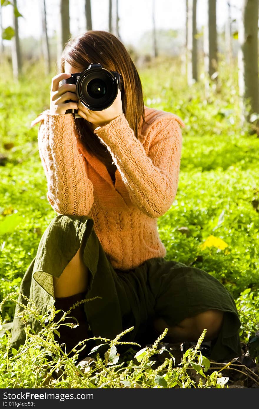 Young female photographer aiming at camera.