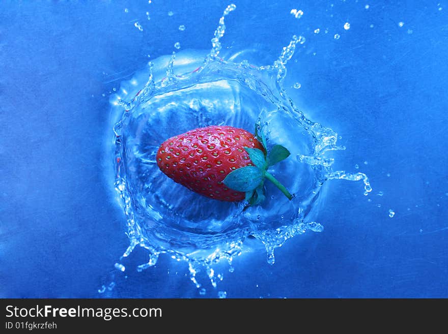 Fresh strawberries splashing into cold water, white balance deliberately set to custom to create feeling of cold and fresh. Fresh strawberries splashing into cold water, white balance deliberately set to custom to create feeling of cold and fresh.