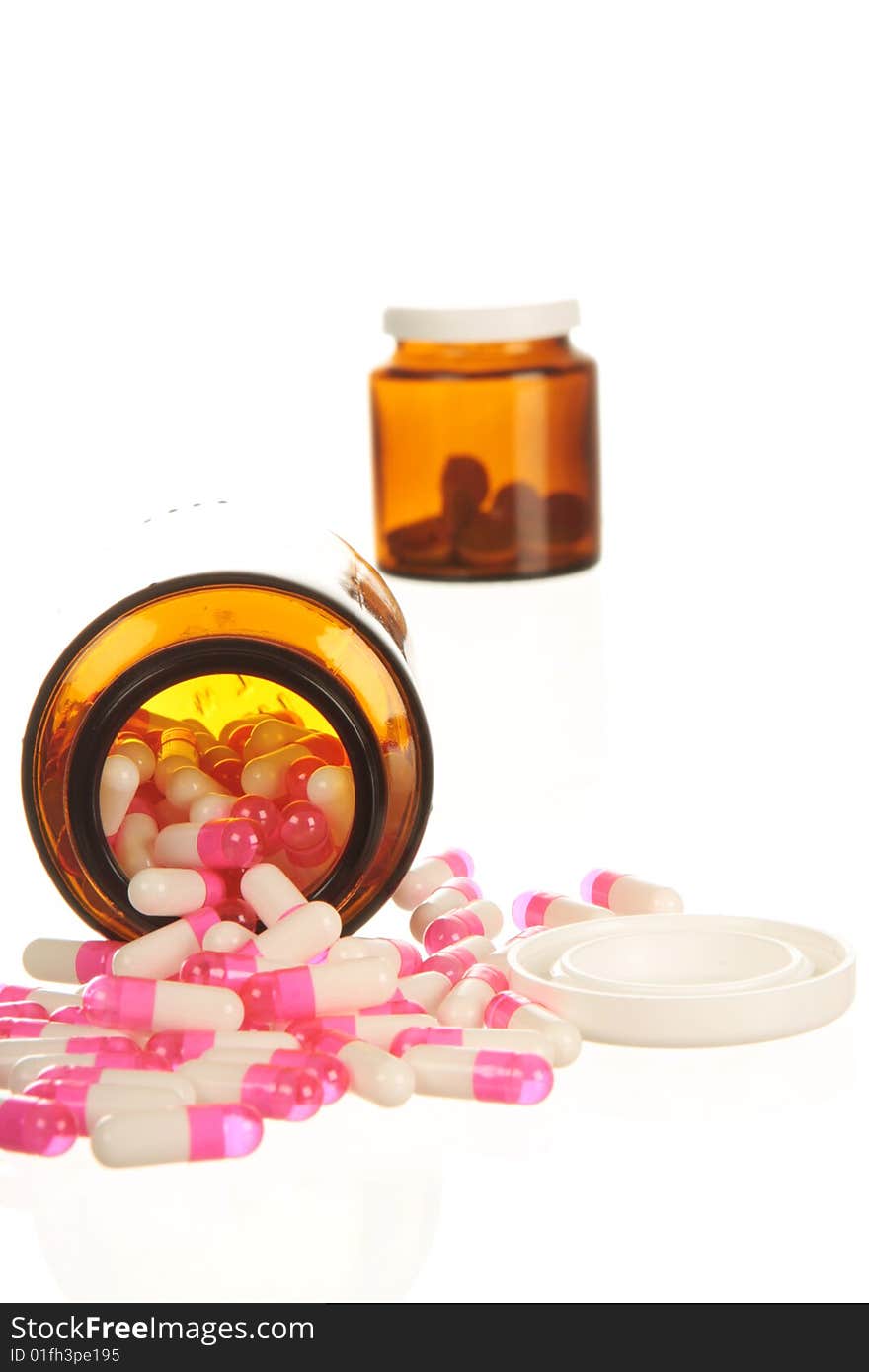 Medicine spilling out of pill bottles, isolated on white with high key lighting. Medicine spilling out of pill bottles, isolated on white with high key lighting