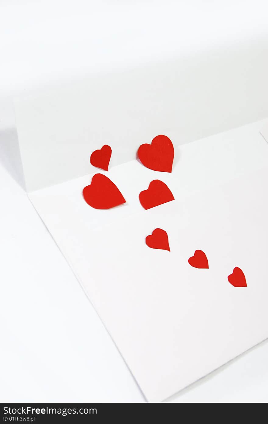 White envelope and red hearts over white. White envelope and red hearts over white