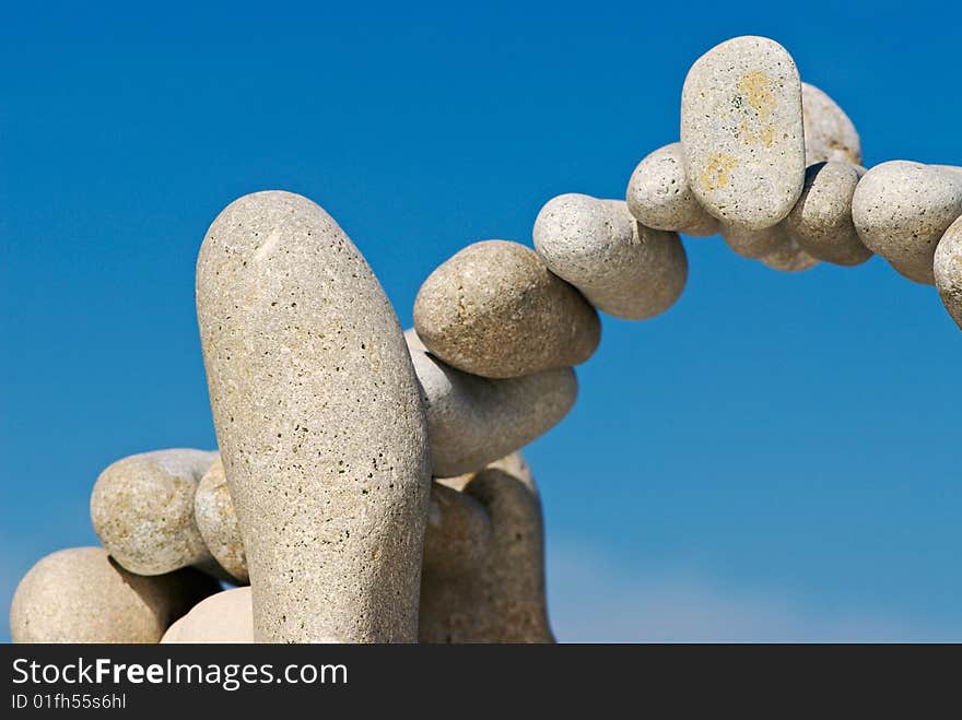 Sea pebble combined in the form of an arch against the sky. Sea pebble combined in the form of an arch against the sky