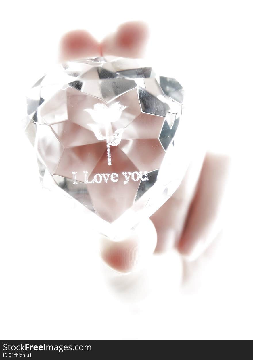Women's hand holds crystal with declaration of love isolated (high key)