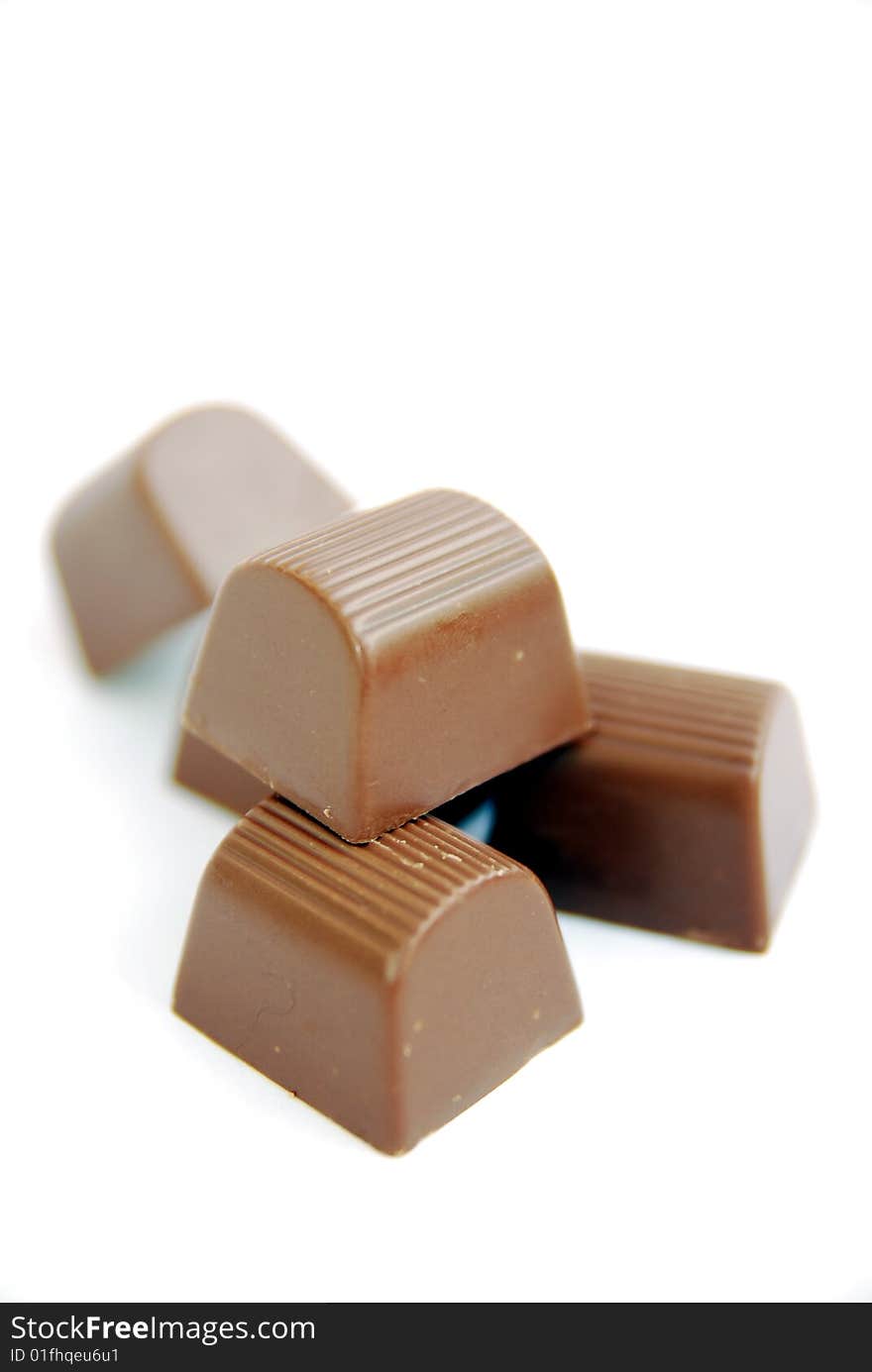 Close up of five brown delicious chocolates on white background