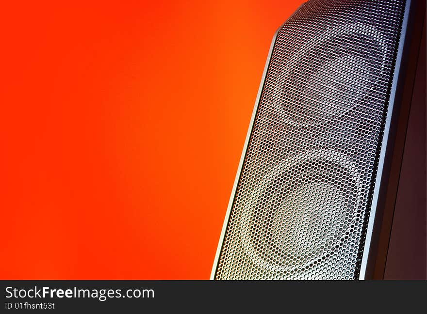 A compact loudspeaker & orange background. A compact loudspeaker & orange background