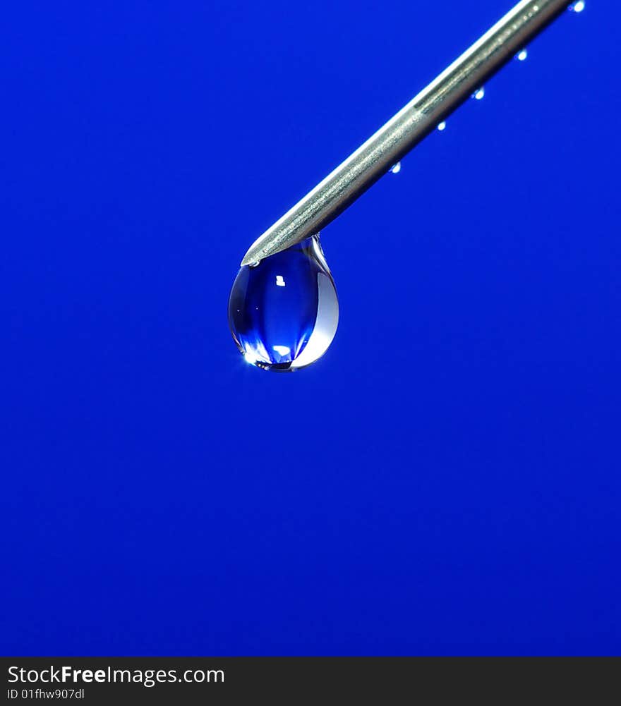 Drop on syringe needle macro on blue