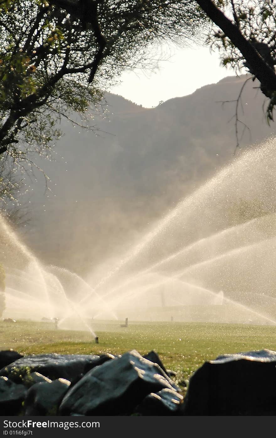 A view of a golf fairway being watered