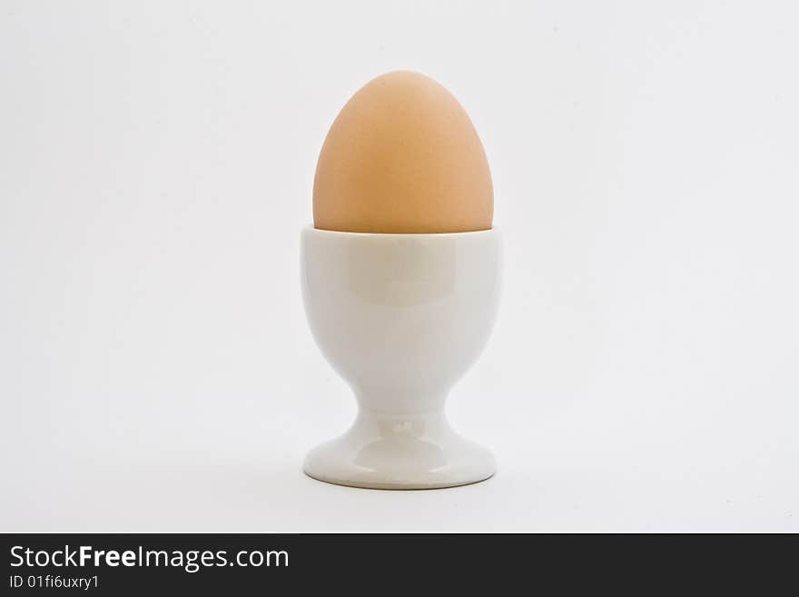 Egg in ceramic eggcup on a white background