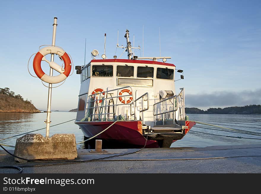 Lifebuoy and a moored ship at a quay.