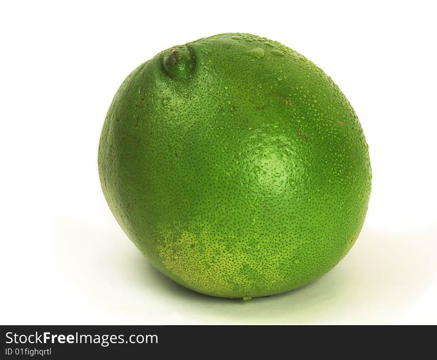 Whole green grapefruit with water drops.