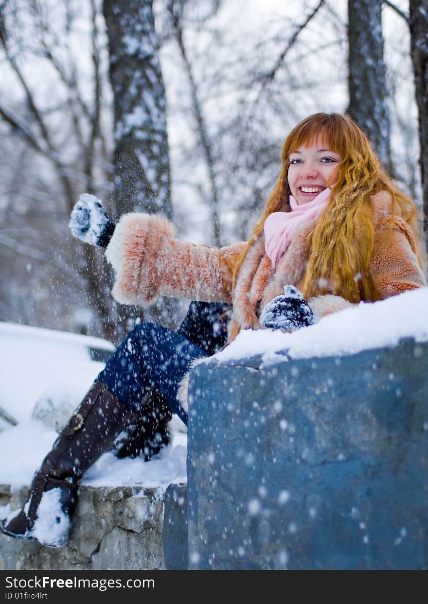 Red-heared girl in short fur coat outdoors - shallow DOF. Red-heared girl in short fur coat outdoors - shallow DOF