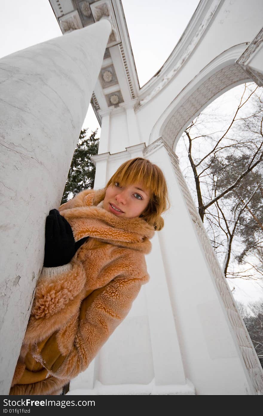 Red-heared girl in short fur coat outdoors - wide angle portrait. Red-heared girl in short fur coat outdoors - wide angle portrait