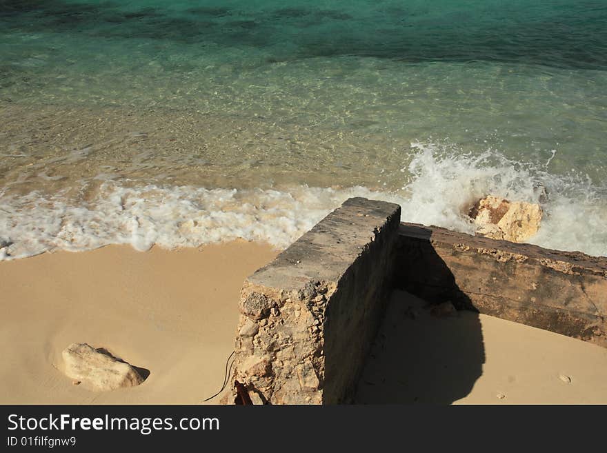 Bright blue water and rocks in the bahamas caribbean with waves splashing on the sand. Bright blue water and rocks in the bahamas caribbean with waves splashing on the sand