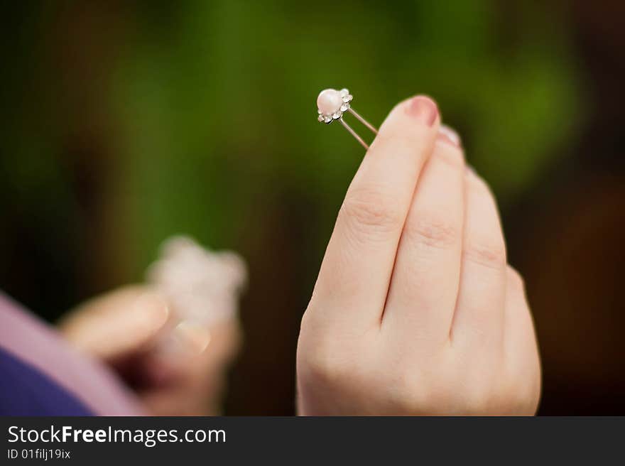 Hairpin with pearls in a female hand. Hairpin with pearls in a female hand