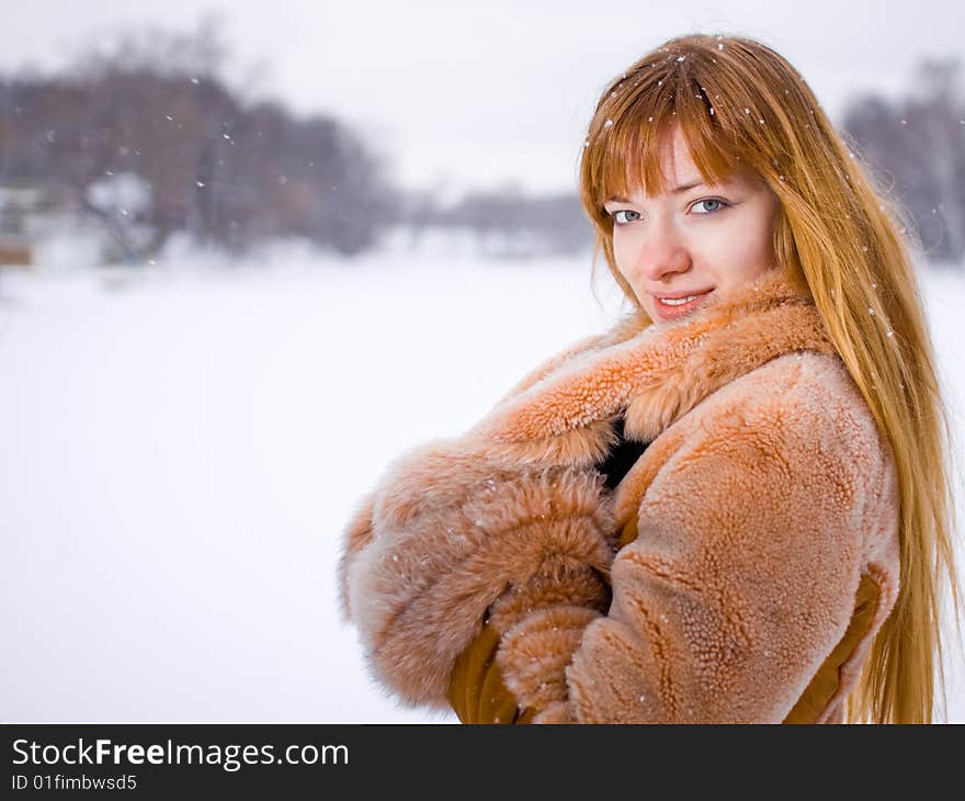 Red-heared girl in fur coat outdoors - shallow DOF. Red-heared girl in fur coat outdoors - shallow DOF