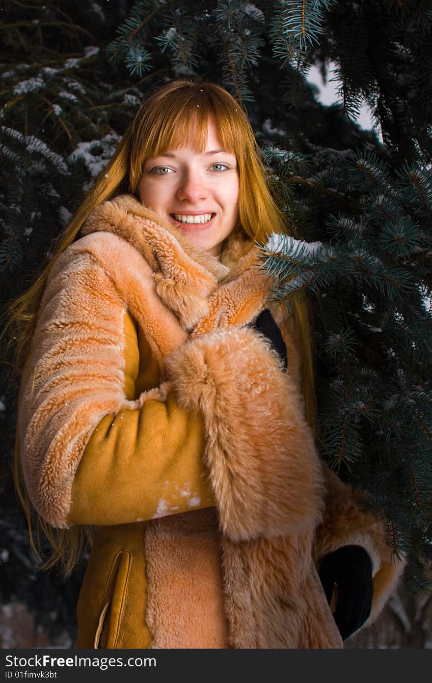 Red-heared girl in fur coat outdoors. Red-heared girl in fur coat outdoors