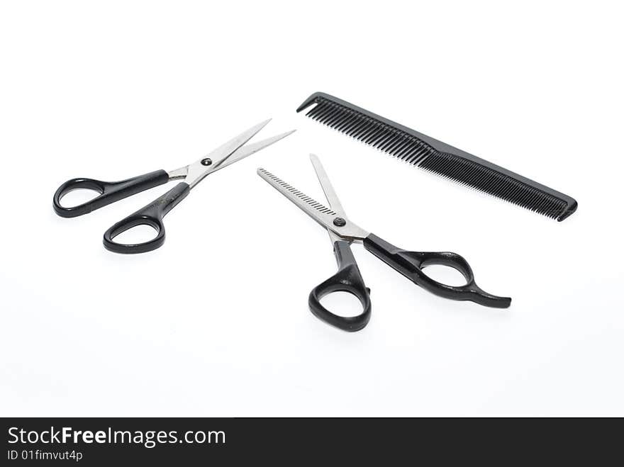 Scissors and comb on the white background