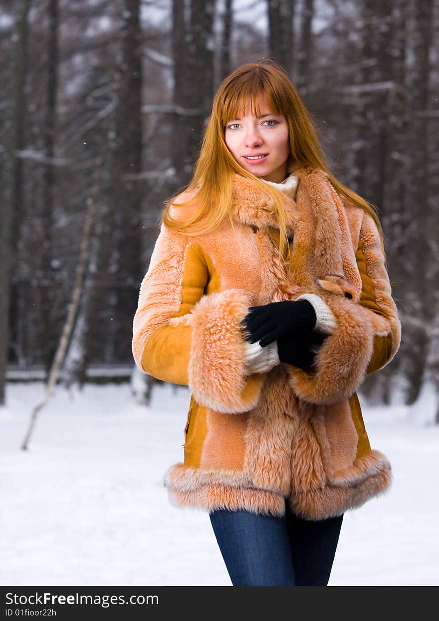 Red-heared girl in short fur coat outdoors - shallow DOF. Red-heared girl in short fur coat outdoors - shallow DOF