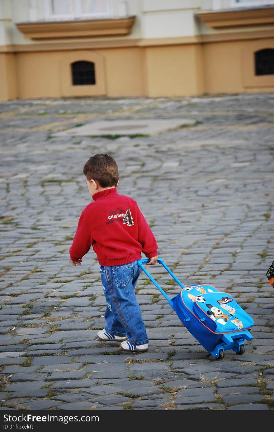 Little boy caring his carry-on. Little boy caring his carry-on