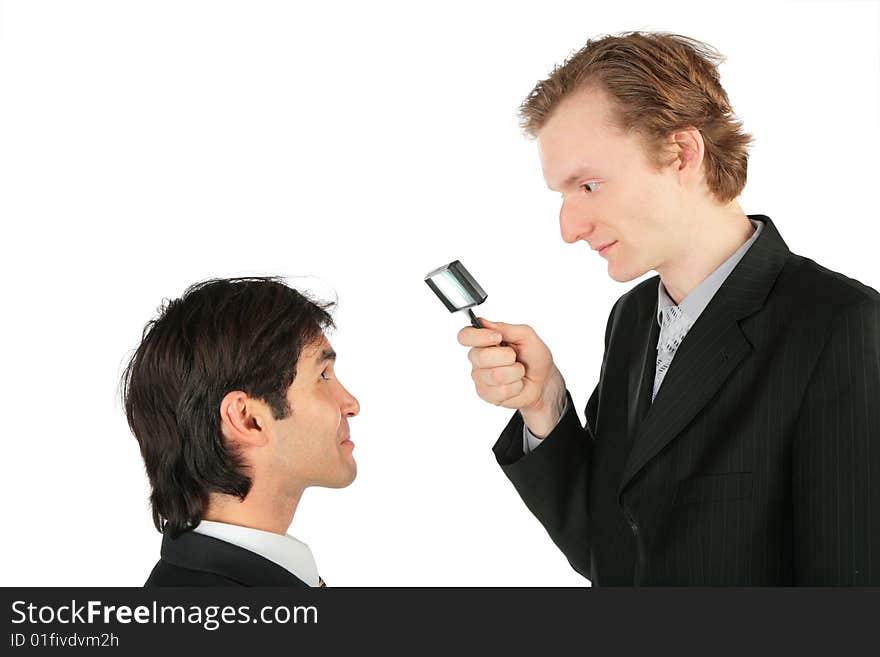 One businessman looks at another through magnifying lens