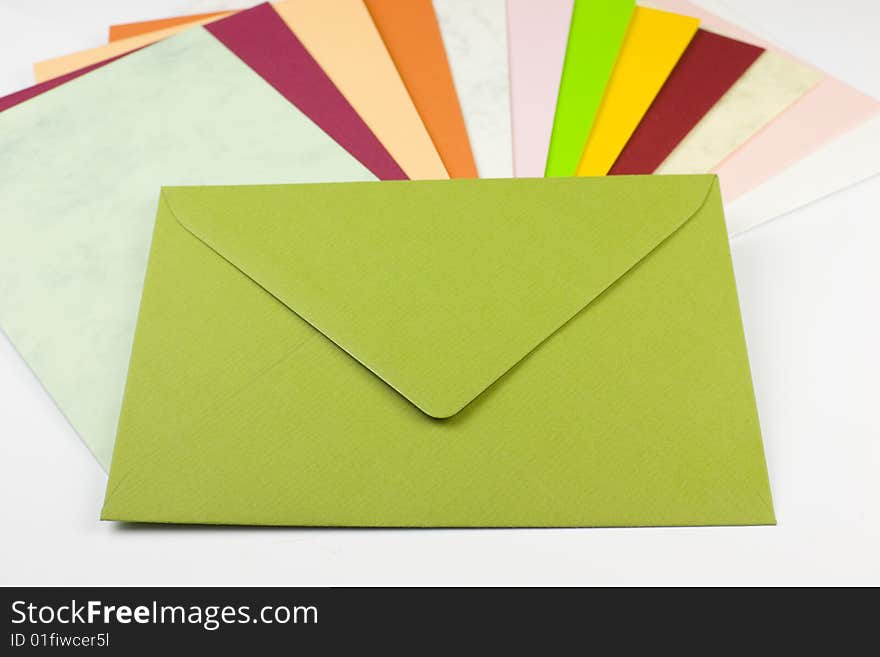 Colorful envelopes arranged in a fan shape with a green letter on top - copy space. Colorful envelopes arranged in a fan shape with a green letter on top - copy space.