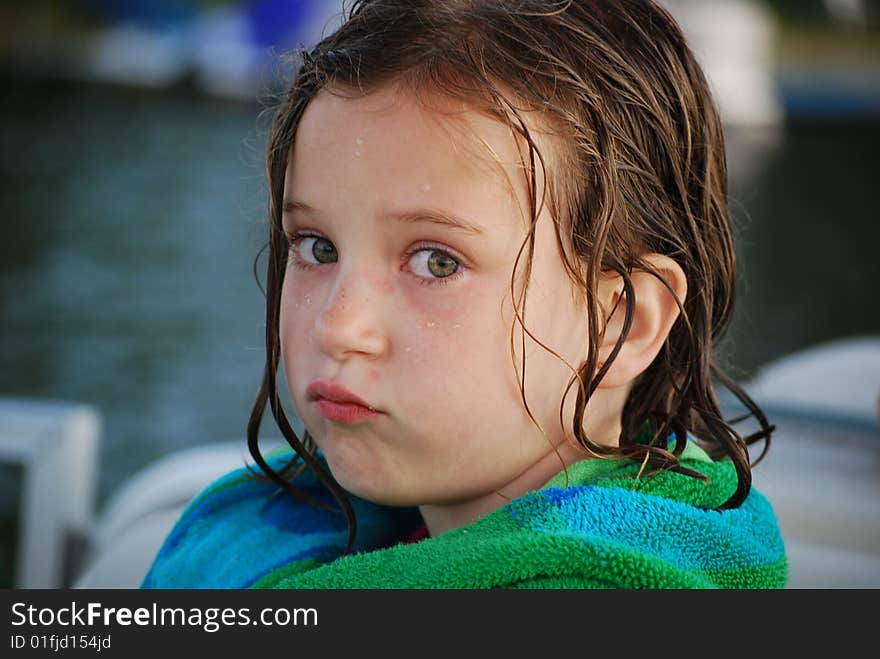 A little girl pouts after a long day of swimming and summer fun. A little girl pouts after a long day of swimming and summer fun