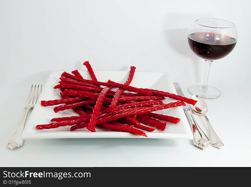 A girls best dinner on a white plate and background along with a red glass of wine. A girls best dinner on a white plate and background along with a red glass of wine.