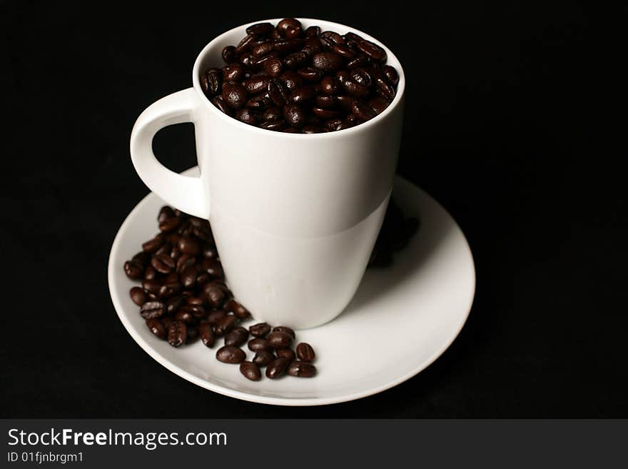 White Coffee cup and coffee beans on black background. White Coffee cup and coffee beans on black background