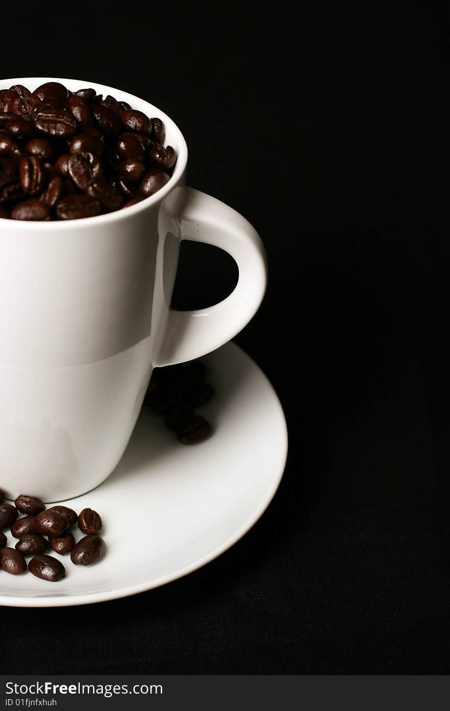 White Coffee cup and coffee beans on white background with space for text. White Coffee cup and coffee beans on white background with space for text