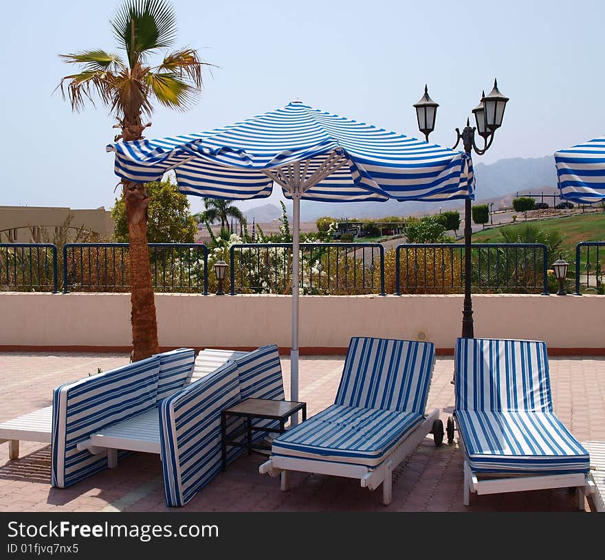 Empty deckchairs wait tourists. Fragment of territory of hotel