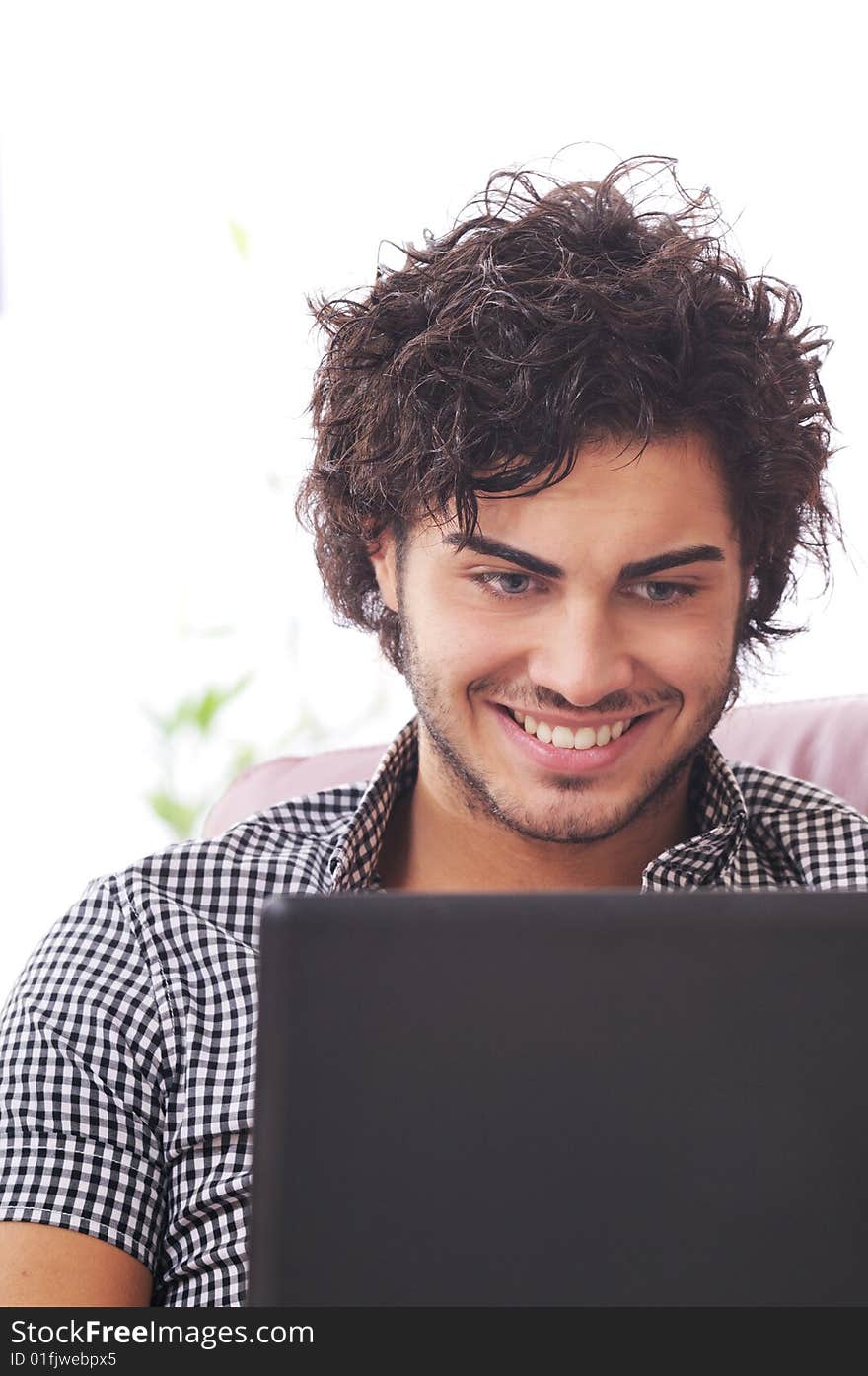 A young man using laptop, happiness and amazement. A young man using laptop, happiness and amazement