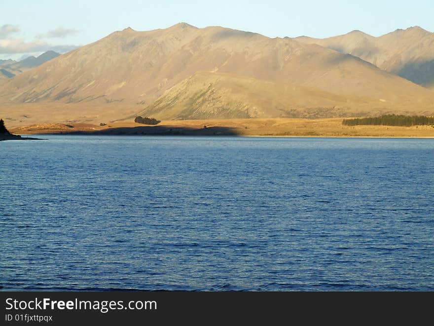 Scenic photo of a Lake with mountains in the background somewhere in New Zealand