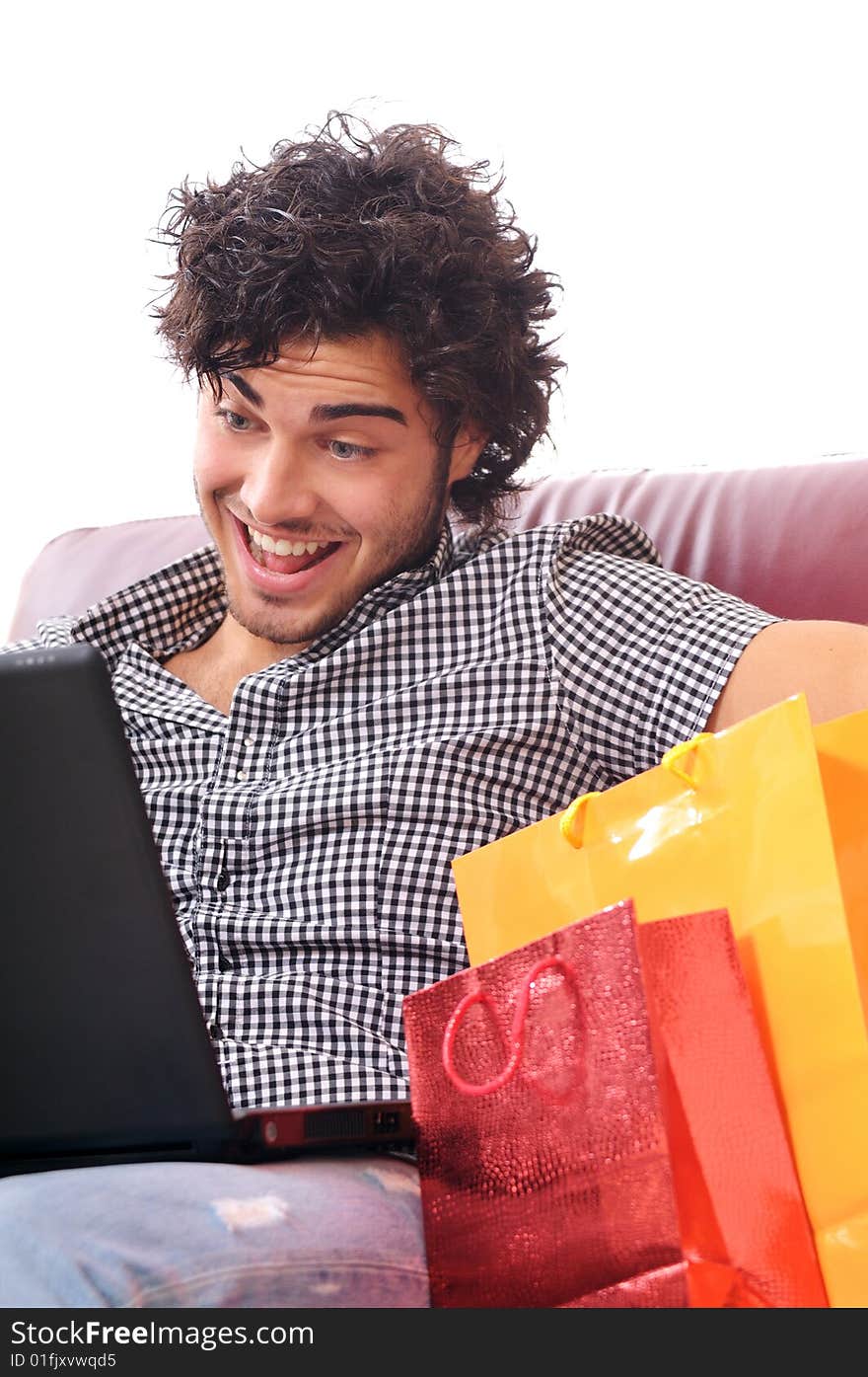 A young man using his credit card to purchase over the internet, happiness and amazement. A young man using his credit card to purchase over the internet, happiness and amazement