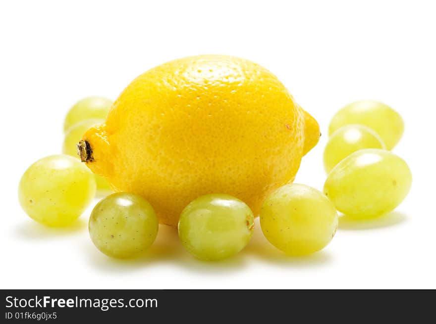 Yellow lemon and green grape isolated on a white background. Yellow lemon and green grape isolated on a white background.