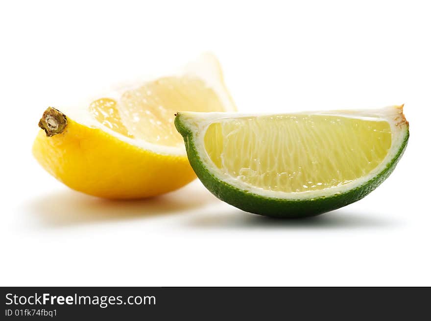 Two pieces of lime and lemon isolated on a white background. Background blurry.