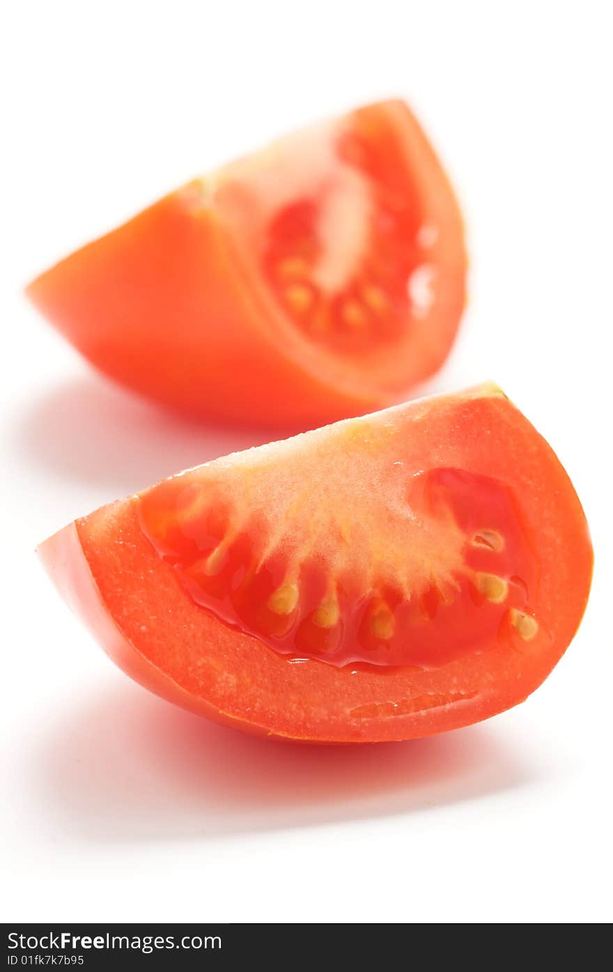 A piece of tomato isolated on a white background. Background blurry. A piece of tomato isolated on a white background. Background blurry.