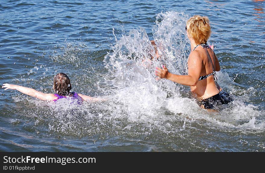 A mom plays with her children in the water. A mom plays with her children in the water